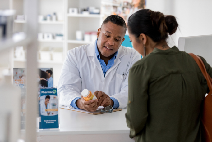 Pharmacist and customer looking at medicine
